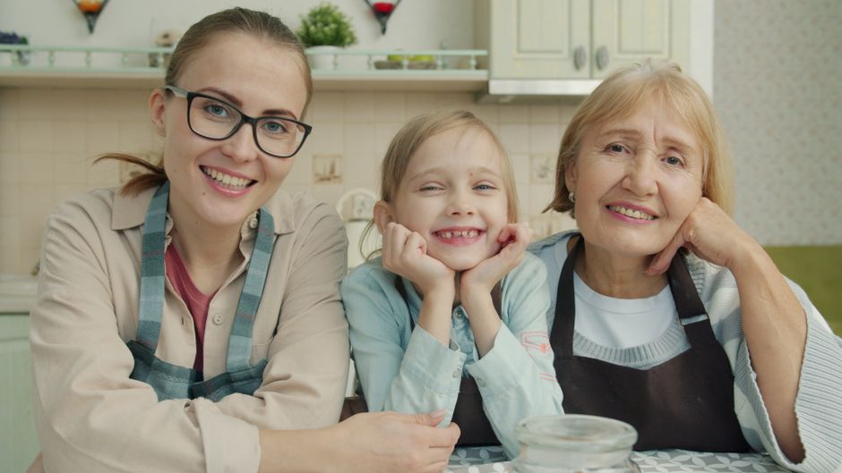 Four women of different ages sharing a heartfelt moment outdoors.