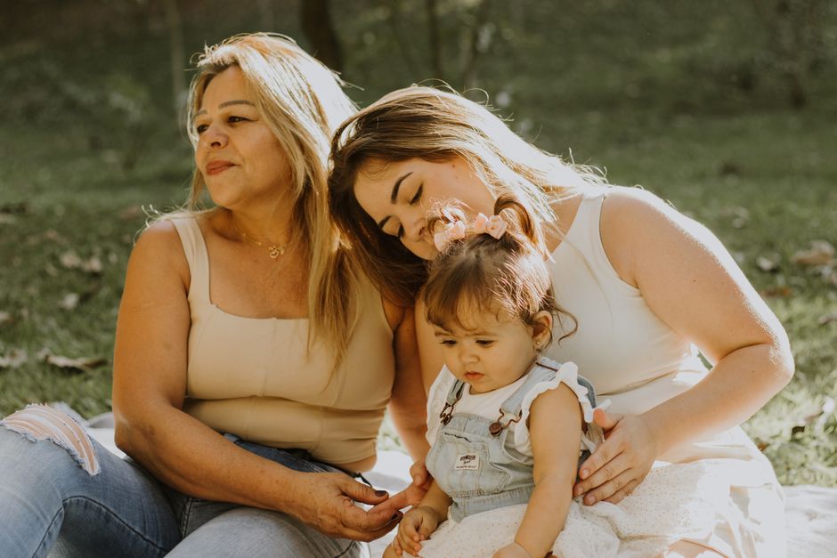 Joyous moment between a mother and daughter, both smiling warmly.