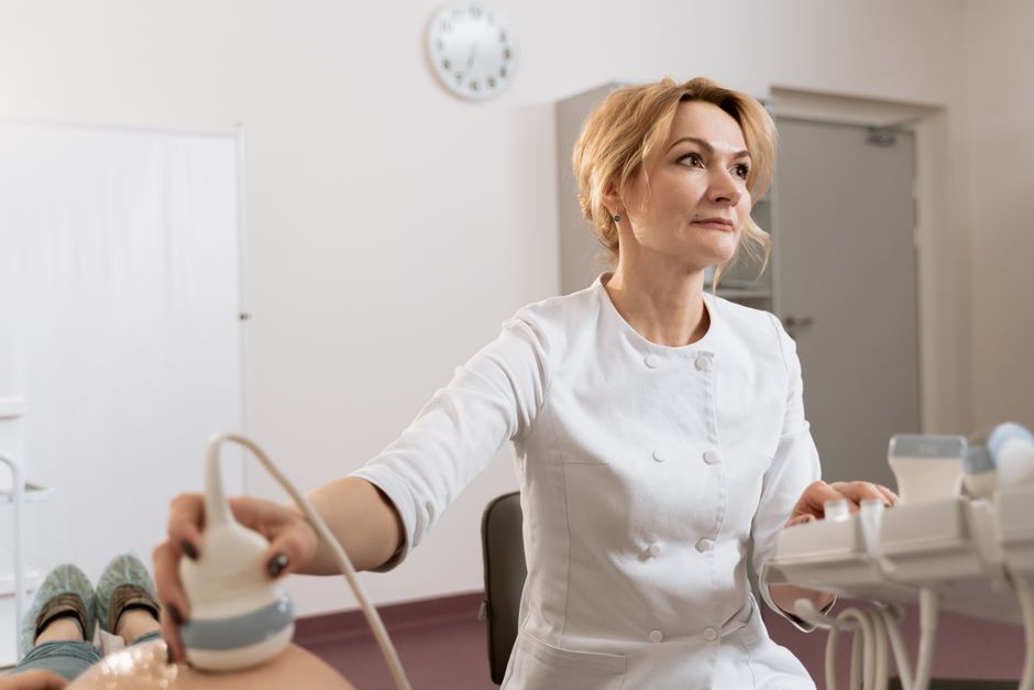 Healthcare professional performing an ultrasound scan on a patient in a medical clinic.